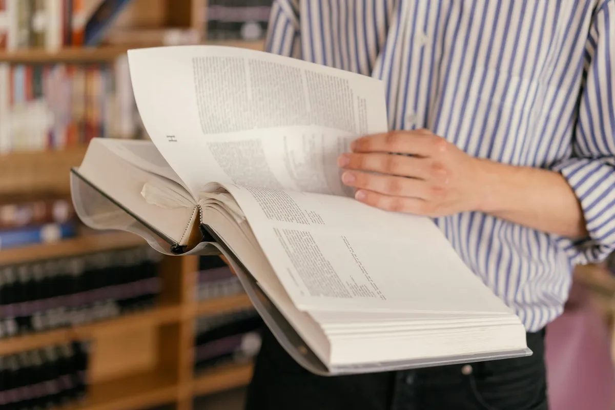 An academic style guide on a study desk with reference books